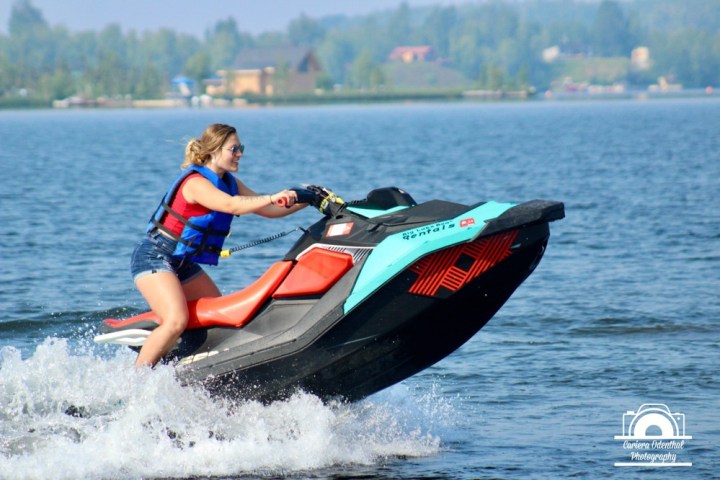 a man riding on the back of a boat in a body of water