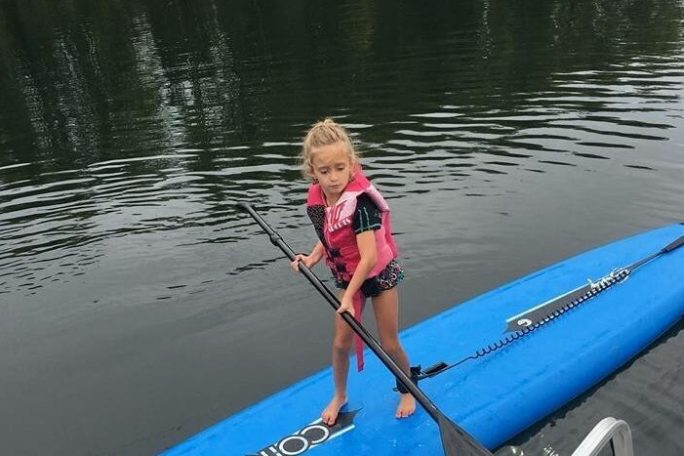 Kid Using Paddle Board On Water